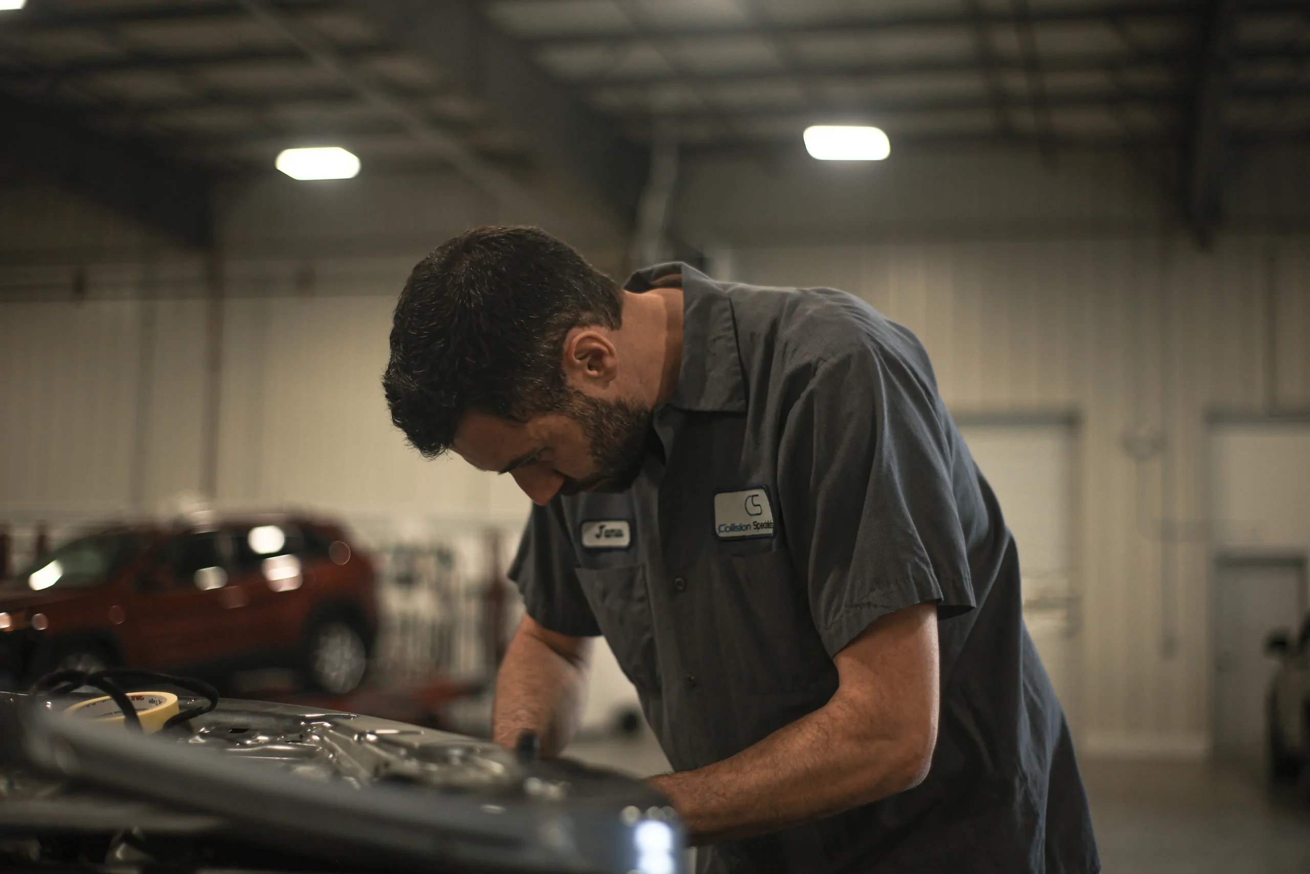 Technician working on a separated panel at Tacoma body repair center