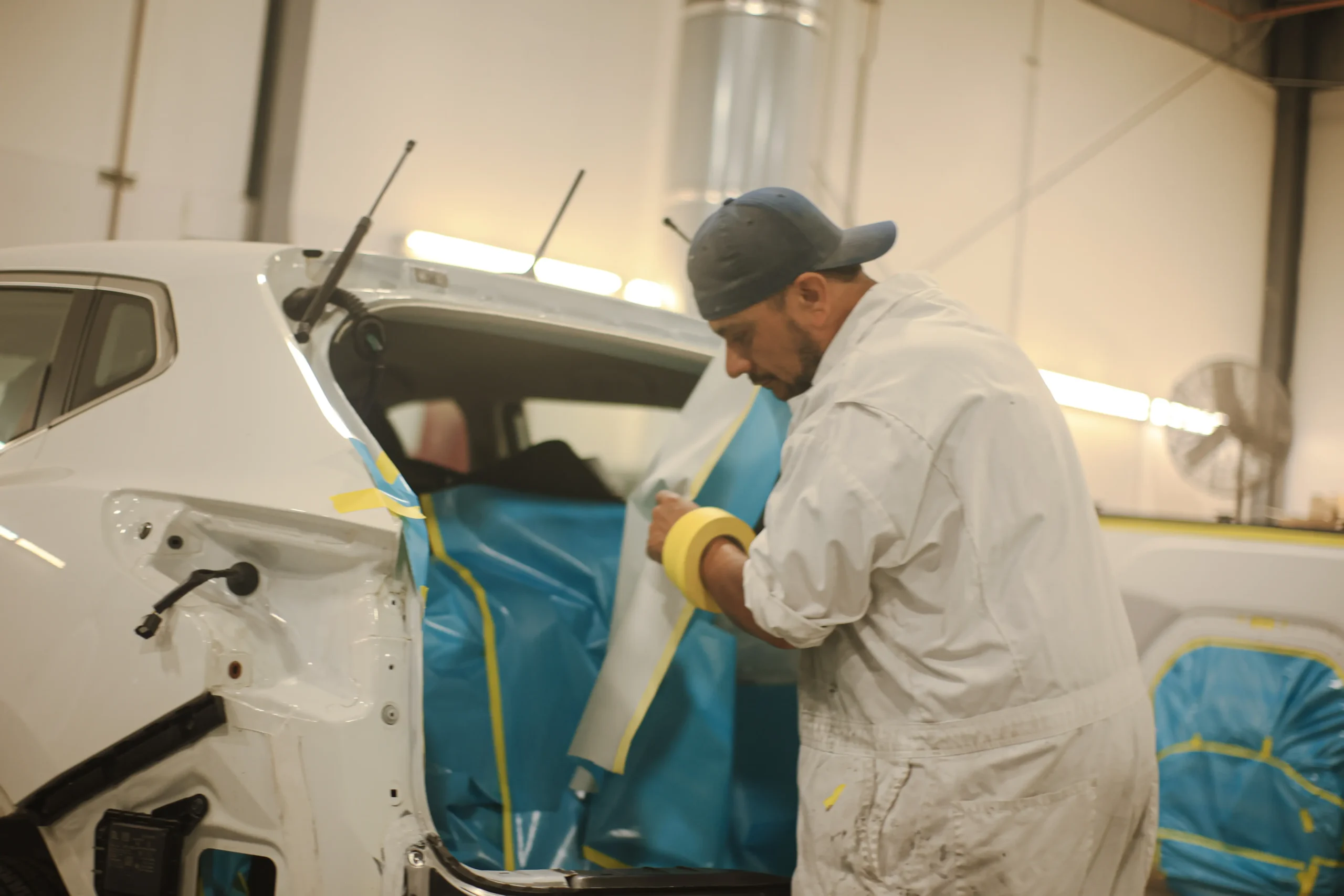 Technician prepping a Nissan Rogue for a paint job at Tacoma Collision Specialists